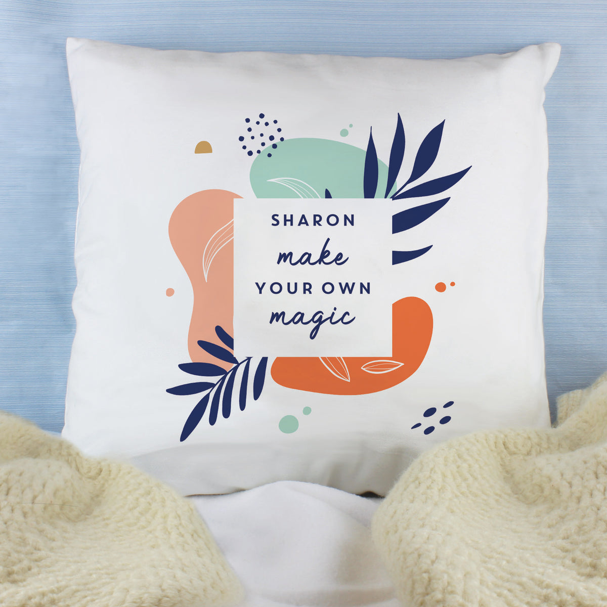 White tropical-print cushion personalised with the name Sharon on a blue chair