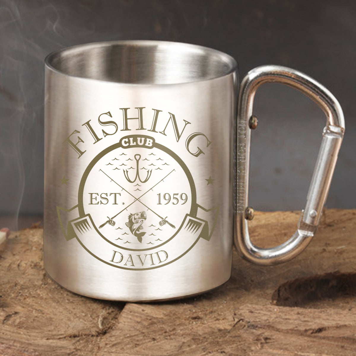 Personalised Fishing Club Stainless Steel Mug with David engraving and fishing emblem on a stone surface.