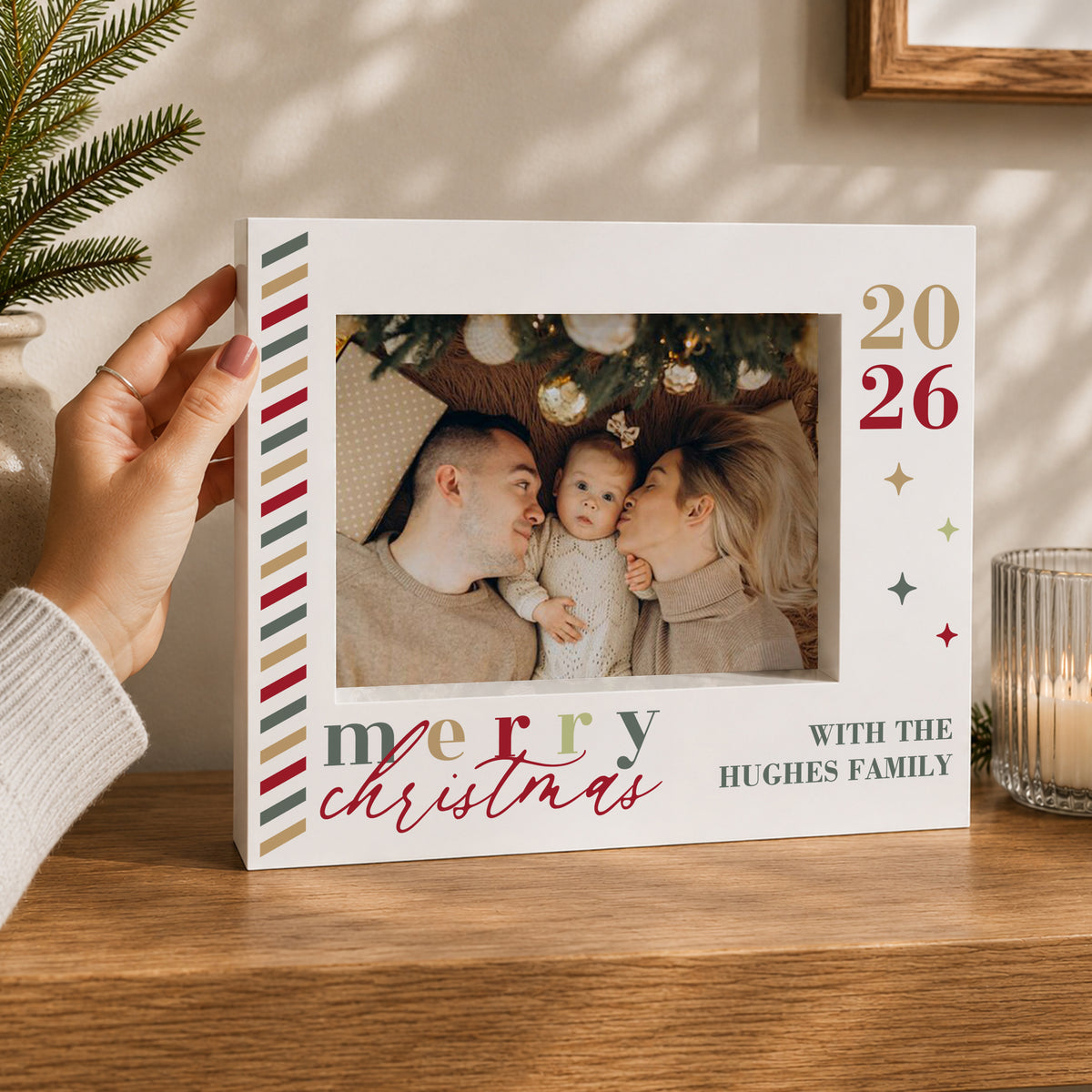 Merry Christmas box frame held beside a baby-and-parents photograph with Hughes Family example wording